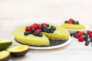 Lezzetli ev yapımı avokado ve limonlu çiğ kek, yabanmersini ve ahududu, sağlıklı vegan tarifleri.