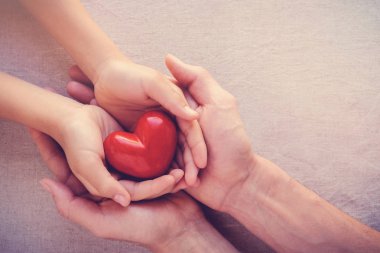 Yetişkin ve çocuk elleri holiding kırmızı kalp, sağlık sevgi, vermek, umut ve Aile kavramı