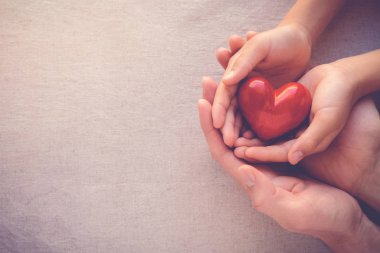 Yetişkin ve çocuk elleri holiding kırmızı kalp, sağlık sevgi ve Aile kavramı
