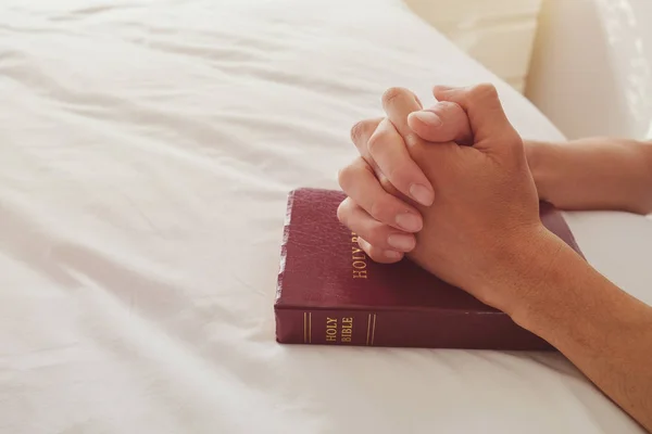 Mãos Orando Com Livro Bíblico Cama Branca — Fotografia de Stock