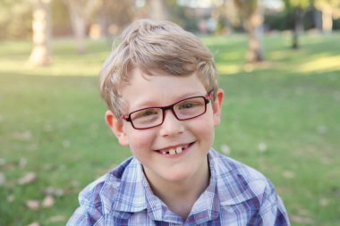 Çim döşeme gözlüklü mutlu küçük çocuk
