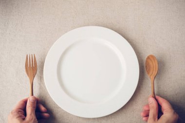 Tablo, ketogenic diyet, kilo kaybı, çatal ve kaşık withwhite tabağa holding insan eller Diyet