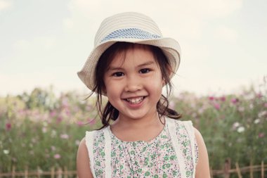 Çiçek alanında gülümseyen sevimli çok kültürlü Asain kız 