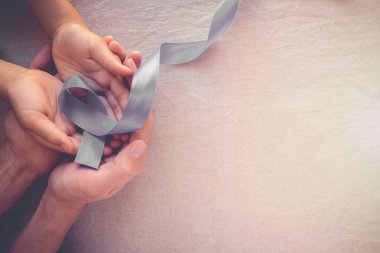 Gri şerit holding insan eller. Dünya kanser günü.