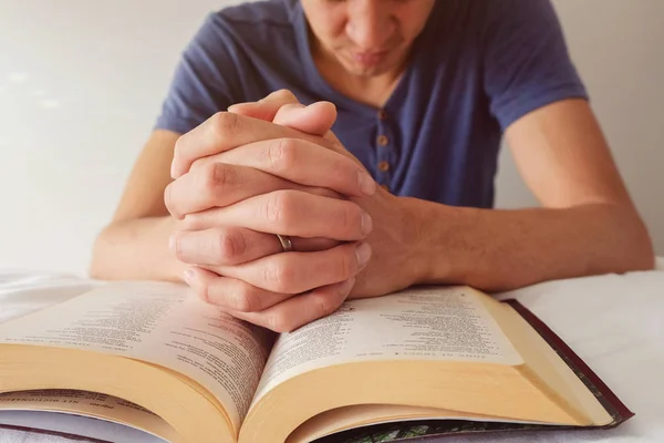 Pregando Mani Dell Uomo Sulla Bibbia Aperta Sul Letto Bianco — Foto Stock