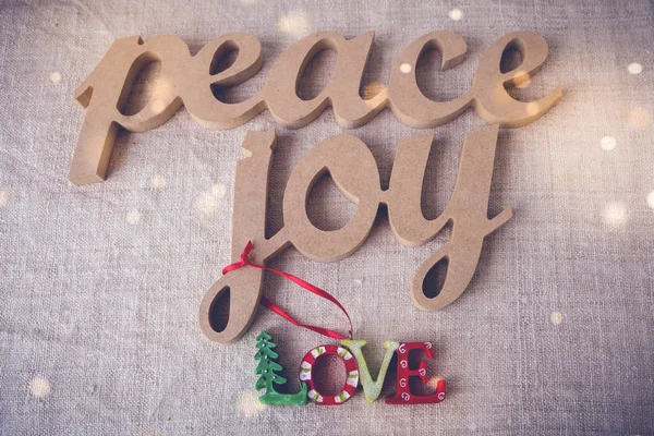 Peace joy love on holiday fairy light toning background