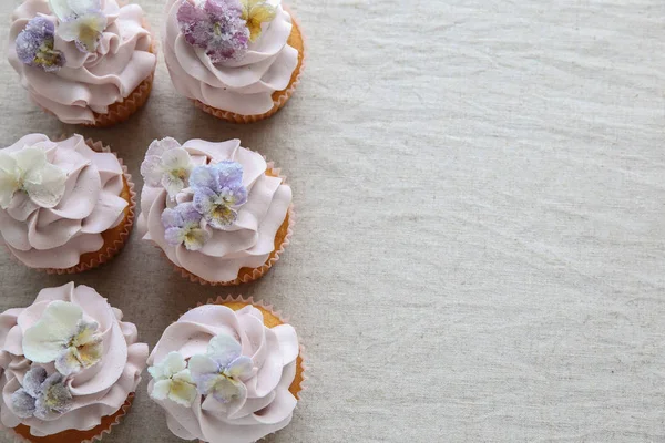 Lila Cupcakes Med Sockrade Ätbara Blommor Kopia Utrymme Bakgrund — Stockfoto
