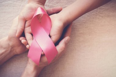 Yetişkin ve Çocuk ellerini tutarak pembe kurdeleler, meme kanseri bilinçlendirme, abdominal kanser farkındalık, Ekim pembe kavramı 