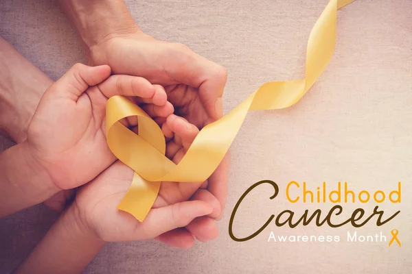 Adult Child Hands Holding Yellow Gold Ribbon Childhood Cancer Awareness — Stock Photo, Image