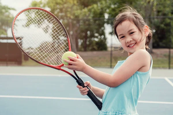 年轻亚洲女孩网球运动员在室外蓝色法院 — 图库照片