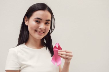 Asyalı Genç kadın tutarak pembe kurdele, meme kanseri bilinçlendirme, Ekim pembe kavramı
