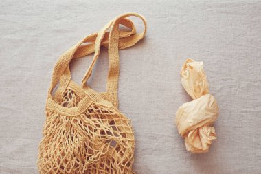 Yeniden kullanılabilir pamuk alışveriş çantası ve gri arka plan üzerinde plastik torba 