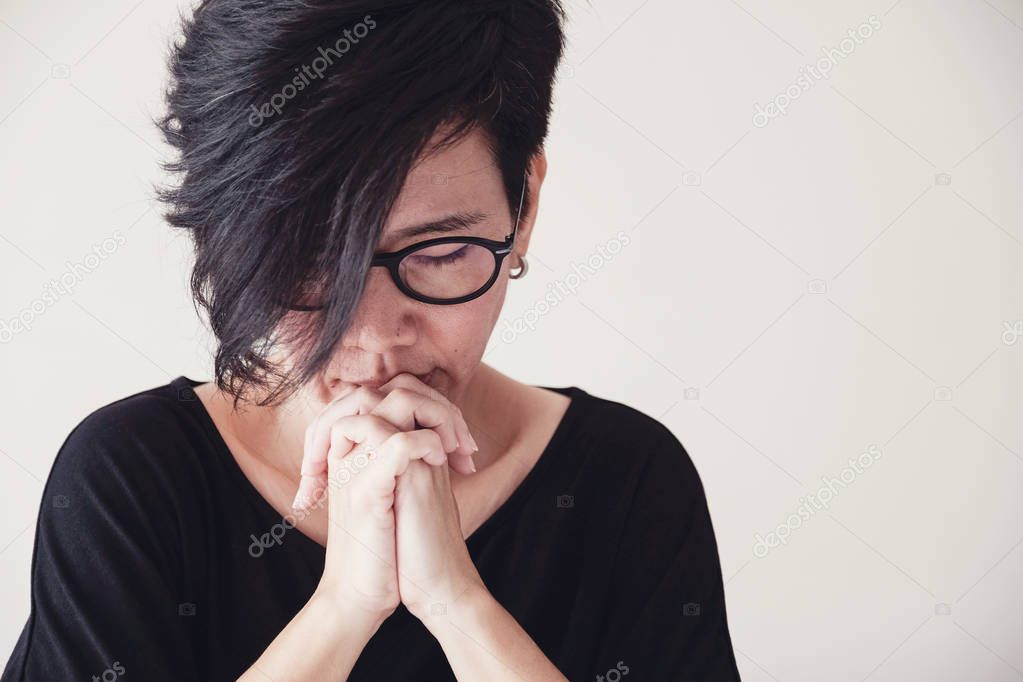 Asian middle aged woman wear glasses praying with hands together