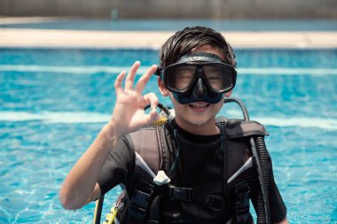 Genç küçük Asyalı çocuk scuba dalgıç ok el sinyali gösteren, Divin