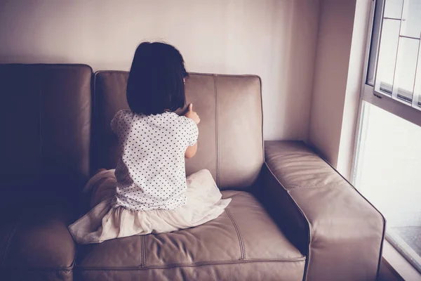 Menina solitária brincando sozinha no sofá em casa, Austismo um — Fotografia de Stock