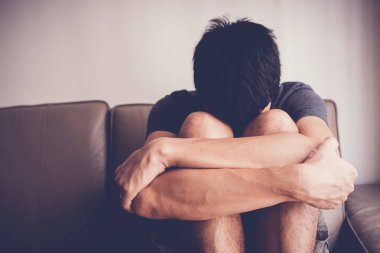 Depresif ve anksiyete genç adam evde yalnız oturan, zihinsel o