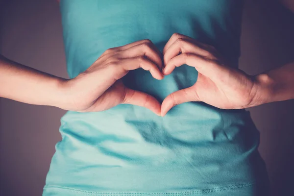 Frauenhände machen eine Herzform auf ihrem Bauch, gesunder Darm — Stockfoto