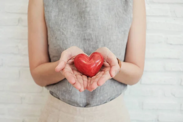 Žena držící červené srdce, zdravotní pojištění, darování charita conc — Stock fotografie