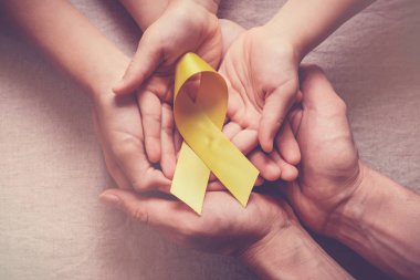 sarı altın kurdele tutan yetişkin ve çocuk elleri, Sarcoma Awa