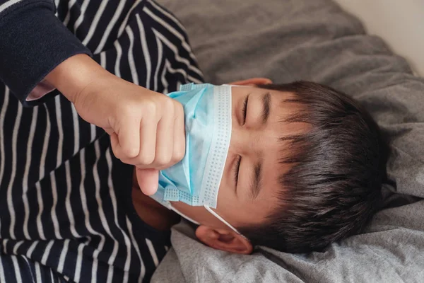 아픈 십대 아시아 소년 착용 a 마스크 과 기침 에 침대 — 스톡 사진