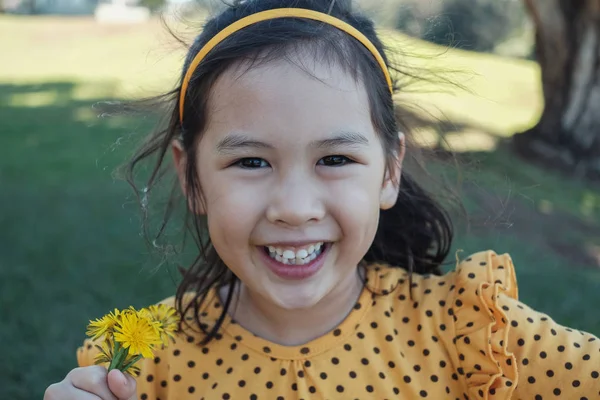 Söt glad och hälsosam blandad asiatisk liten flicka klädd i gult Po — Stockfoto