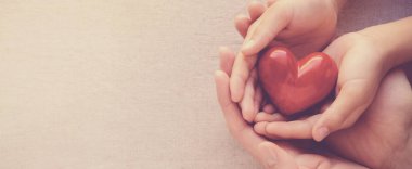 yetişkin ve çocuk elleri holiding kırmızı kalp, kalp sağlık ve bağış