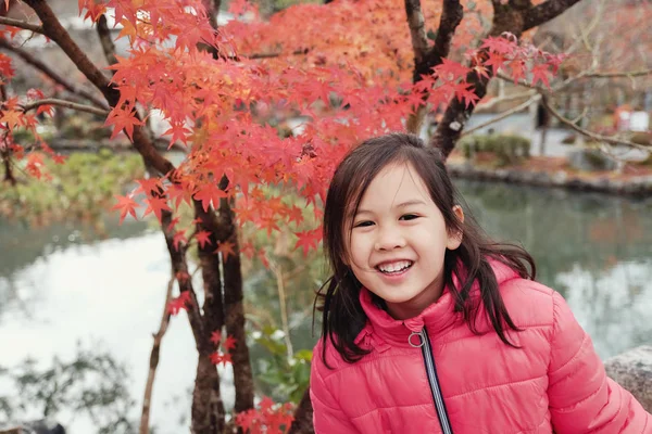 Lycklig liten asiatisk tjej leende framför japanska röd lönn l — Stockfoto