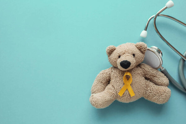 Children soft toy brown bear with yellow gold ribbon and stethos