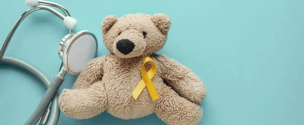 Children soft toy brown bear with yellow gold ribbon and stethos