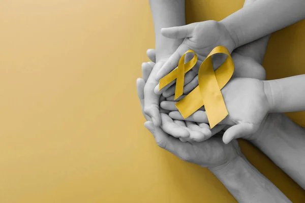 Adult and children hands holding yellow gold ribbon, Sarcoma Awa — Stock Photo, Image