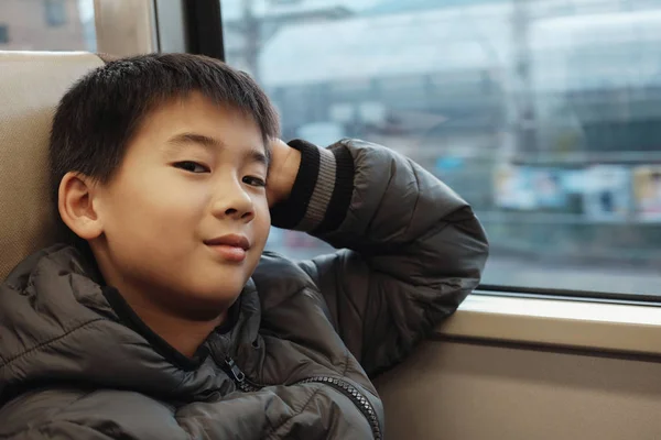 Portrait of tween mixed Asian boy in public train, preteen trave — Stock Photo, Image