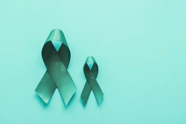 Šedomodré stuhy na modrém pozadí, Ovarijská rakovina, krční rakovina — Stock fotografie
