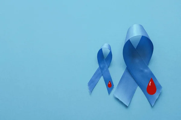 浅蓝色丝带与蓝色背景的血，世界糖尿病 — 图库照片