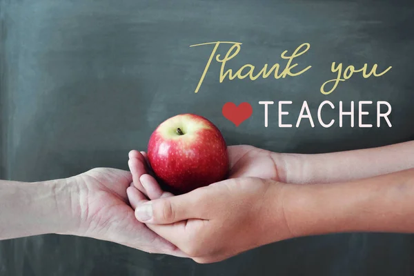 Opiskelija ja opettaja kädet tilalla punainen omena liitutaulu takaisin — kuvapankkivalokuva