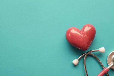 Mavi arka planda steteskoplu kırmızı kalp, kalp sağlığı, o