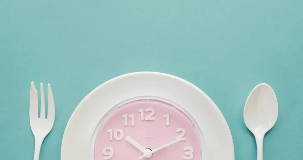 Pink clock on white plate, Intermittent fasting concept, ketogen — Stock Photo, Image