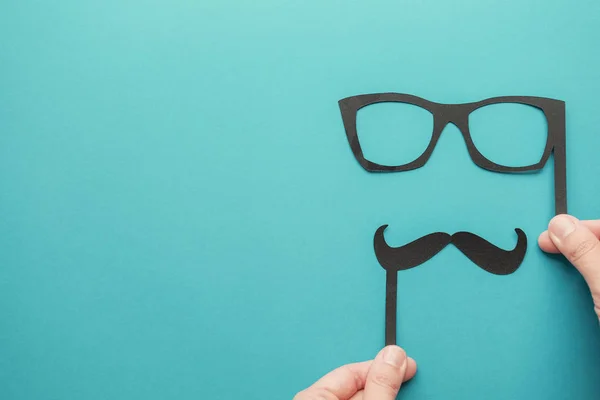 Manos sosteniendo bigote de papel y gafas, los hombres azules de noviembre sanan — Foto de Stock