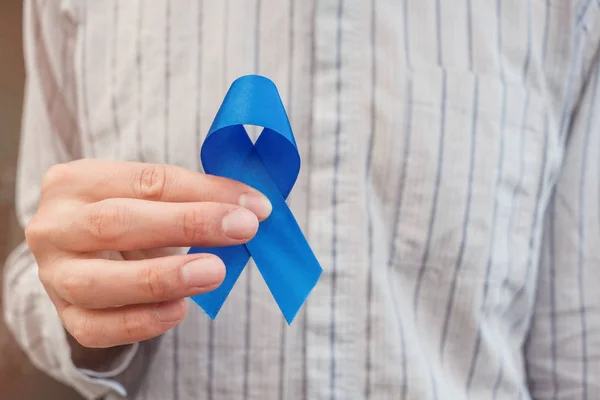 Man Hands holding blue ribbon, Prostate Cancer Awareness, Novemb — Stock Photo, Image