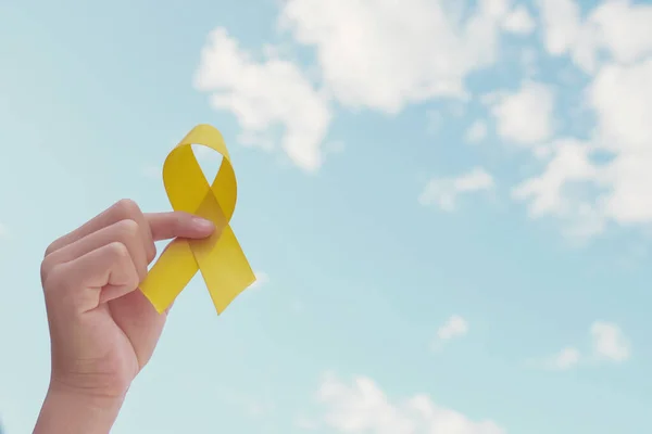 Ruce Držící Žlutou Zlatou Stuhu Přes Modrou Oblohu Sarkom Povědomí — Stock fotografie