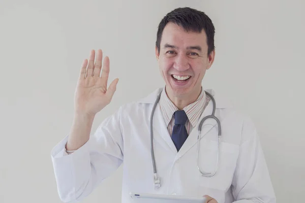 Mixed race Asian medical male online doctor waving his hand and working remotely, telehealth, telemedicine, distance consulting concept