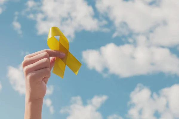 Mavi Gökyüzünde Sarı Altın Kurdele Tutan Eller Sarkoma Bilinci Kemik — Stok fotoğraf