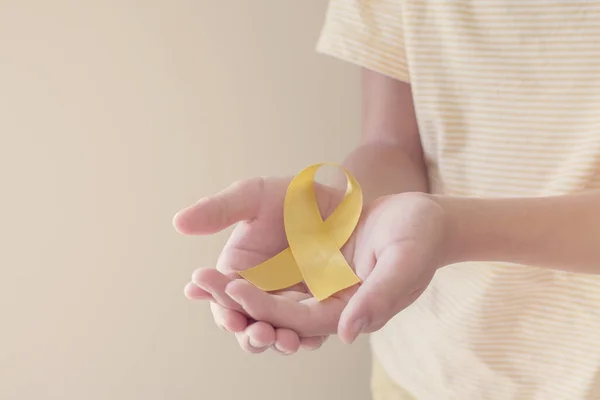 Mãos Segurando Fita Ouro Amarelo Consciência Sarcoma Câncer Ósseo Consciência — Fotografia de Stock