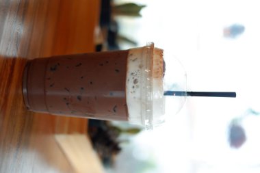 Eski ahşap masa arkasında kahve fincanı ve kahve çekirdekleri. Mesaj için yer var.