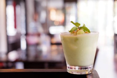 Serin içecekler ve ahşap masada avokado içecekleri, mesaj için yer.