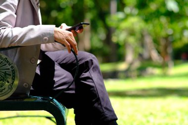 İş adamı akıllı telefon kullanıyor ve iş gazetesi okuyor.