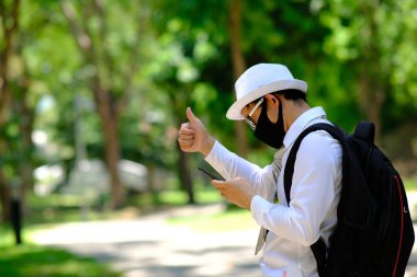 İş adamı akıllı telefon kullanıyor ve dışarıda iş haberleri okuyor.