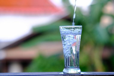 Ahşap masa arkaplanına ve alana içme suyu dökülüyor