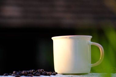 Ahşap arka planda kahve fincanı ve kahve çekirdeği.