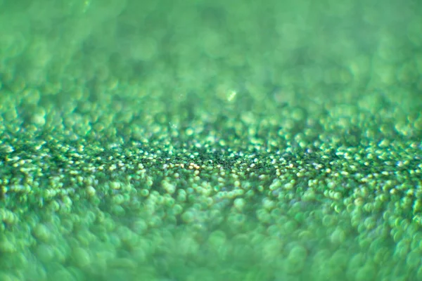 Green glitter surface with green light bokeh and Blurred abstract holiday