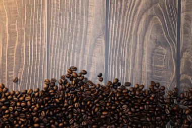 Kahve fincanı ve kahve çekirdekleri ahşap masada, mesaj için yer var.